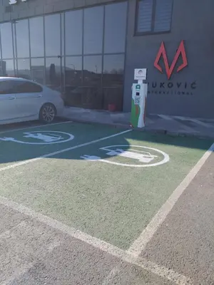 a white car parked in a parking lot with aania sign at Motel Bihać in Bihać