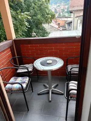 a patio with a table and chairs on a balcony at Apartment and rooms
