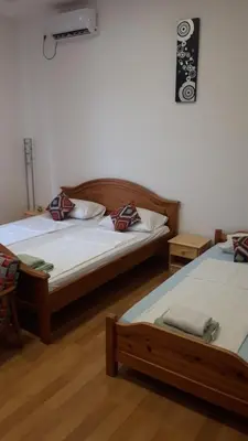 two twin beds in a room with wooden floors at Apartment and rooms