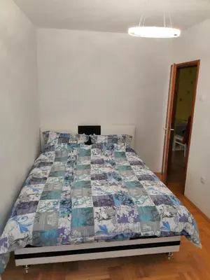 a bedroom with a bed with a quilt on it at Milgor in Banja Luka