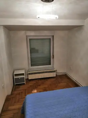 a bedroom with a bed and a window with a fan at Milgor in Banja Luka