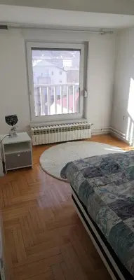 a bedroom with a bed and a large window at Milgor in Banja Luka