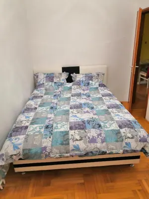 a bed with a quilt on it in a bedroom at Milgor in Banja Luka