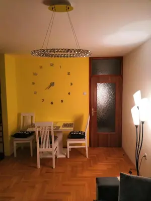 a dining room with a table and chairs and a yellow wall at Milgor in Banja Luka