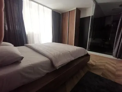 a bed in a room with a large window at City-centar in Banja Luka