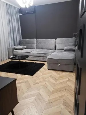 a living room with a couch and a wooden floor at City-centar in Banja Luka