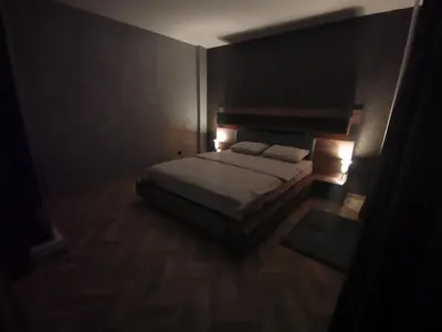 a bedroom with a bed in a dark room at City-centar in Banja Luka
