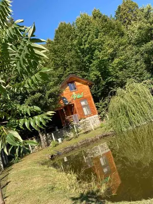 a small house with a sign on the side of it at Vikendice Bungalovi Menzil in Zavidovići