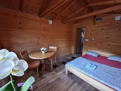 a bedroom with a bed and a table in a room at Vikendice Bungalovi Menzil in Zavidovići