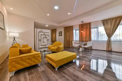 a living room with yellow furniture and a table at Royal Residence Deluxe Apartments in Bihać