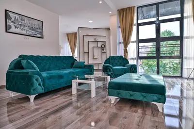 a living room with a green couch and two chairs at Royal Residence Deluxe Apartments in Bihać