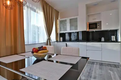 a kitchen with a table with a bowl of fruit on it at Royal Residence Deluxe Apartments in Bihać