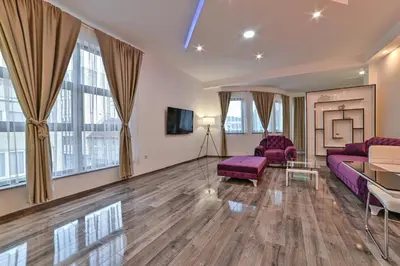 a living room with purple furniture and large windows at Royal Residence Deluxe Apartments in Bihać
