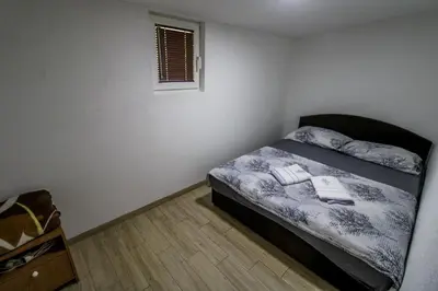 a small bedroom with a bed in the corner at ''Lake House Jana'' Ramsko Jezero in Prozor