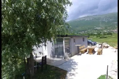 a small white house with a tree in front of it at ''Lake House Jana'' Ramsko Jezero in Prozor