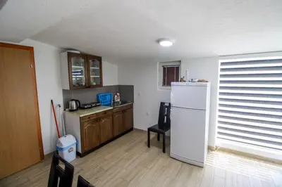 a kitchen with a white refrigerator and a table at ''Lake House Jana'' Ramsko Jezero in Prozor
