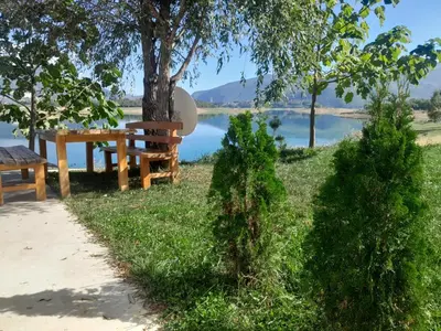 a picnic table and bench next to a lake at ''Lake House Jana'' Ramsko Jezero in Prozor
