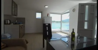 a kitchen with a glass table with a bottle of wine at ''Lake House Jana'' Ramsko Jezero in Prozor