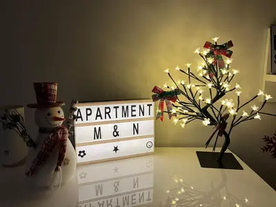 a table with a snowman and a calendar and a christmas tree at Apartment M & N in Banja Luka