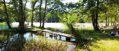 a park with a wooden bridge in the water at Paulinio in Jajce