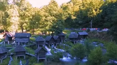a group of wooden cottages in a river at Paulinio in Jajce