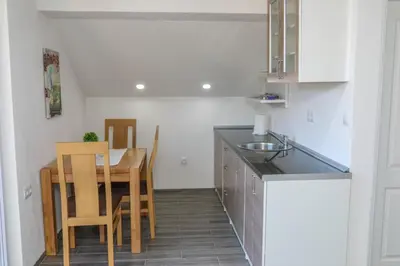 a kitchen with a table and a dining room at Paulinio in Jajce