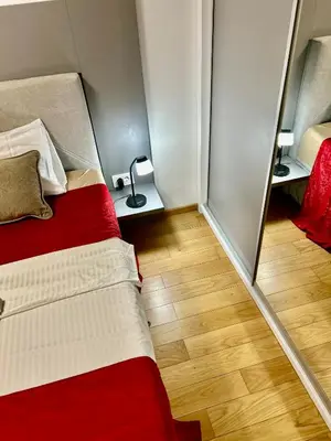 a small room with a bed and a mirror at Apartman Nova Varos Banjaluka in Banja Luka