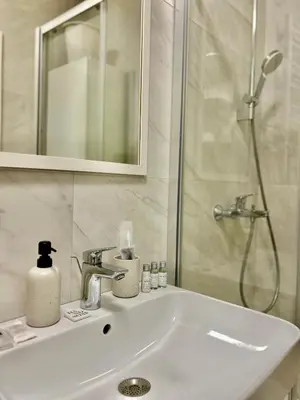 a bathroom with a sink and a shower at Apartman Nova Varos Banjaluka in Banja Luka