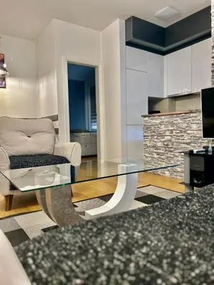 a living room with a glass table and a couch at Apartman Nova Varos Banjaluka in Banja Luka
