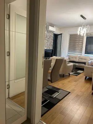 a living room with chairs and a living room with a couch at Apartman Nova Varos Banjaluka in Banja Luka