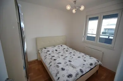 a small bed in a room with a window at Apartman Venecija in Banja Luka