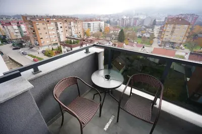 a balcony with two chairs and a table on a building at Apartman Venecija in Banja Luka