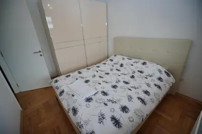a small bed in a small room with a bedspread on it at Apartman Venecija in Banja Luka