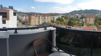 a balcony with a chair and a view of a city at Apartman Venecija in Banja Luka