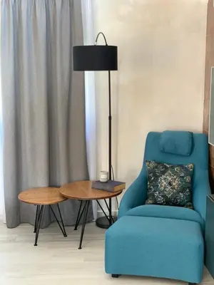 a blue chair and a lamp next to a table at Family resort TRAPISTI in Banja Luka