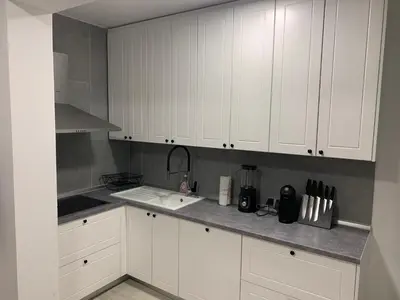 a kitchen with white cabinets and a sink at Family resort TRAPISTI in Banja Luka