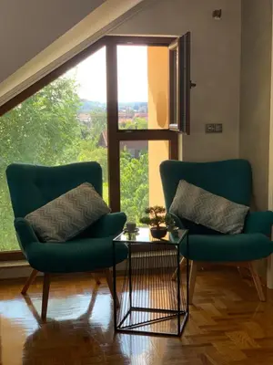 two chairs and a table in a room with a large window at Family resort TRAPISTI in Banja Luka