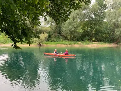 two people in a red canoe on a lake at Villa Nana in Kulen Vakuf