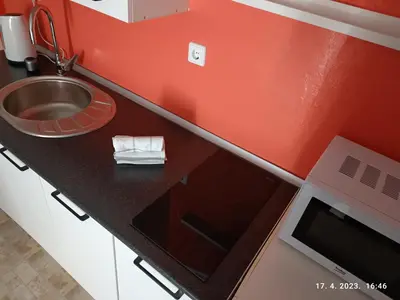 a red kitchen with a sink and a counter with a sink at Villa Nana in Kulen Vakuf