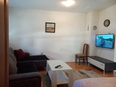 a living room with a couch and a tv on a wall at Apartman Stepa in Banja Luka
