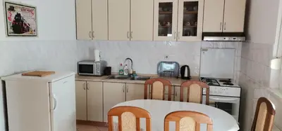 a kitchen with white cabinets and a table and chairs at Apartman Stepa in Banja Luka