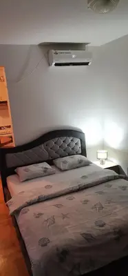 a bed sitting in a bedroom with avertisementatronatronstrationstrationstration at Apartman Stepa in Banja Luka