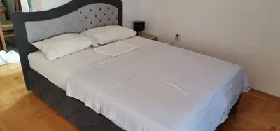 a large bed with white sheets and pillows on it at Apartman Stepa in Banja Luka