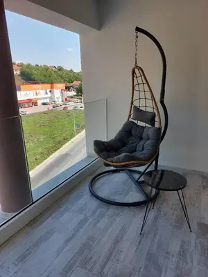 a swing chair in a room with a window at Motel Bajra in Travnik