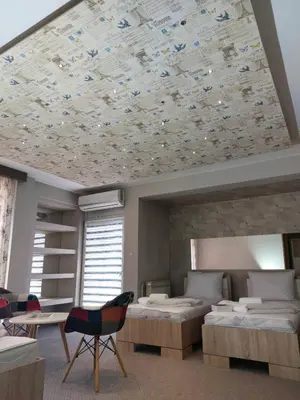 a bedroom with two beds and a ceiling covered in flowers at Motel Bajra in Travnik