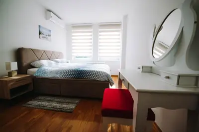 a bedroom with a bed and a mirror and a desk at Apartman Oaza in Banja Luka