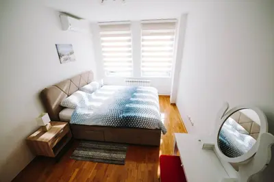 a small bedroom with a bed and a mirror at Apartman Oaza in Banja Luka