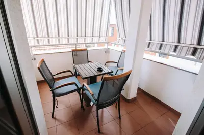 a table and chairs in a room with windows at Apartman Oaza in Banja Luka