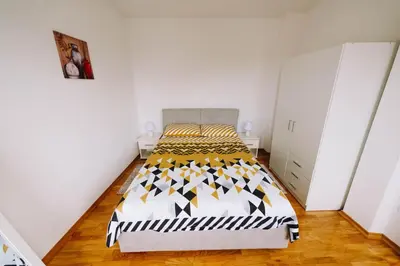 a bedroom with a bed in a white room at Apartman Oaza in Banja Luka