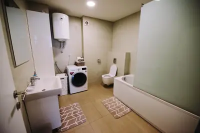 a bathroom with a sink and a washing machine at Apartman Oaza in Banja Luka